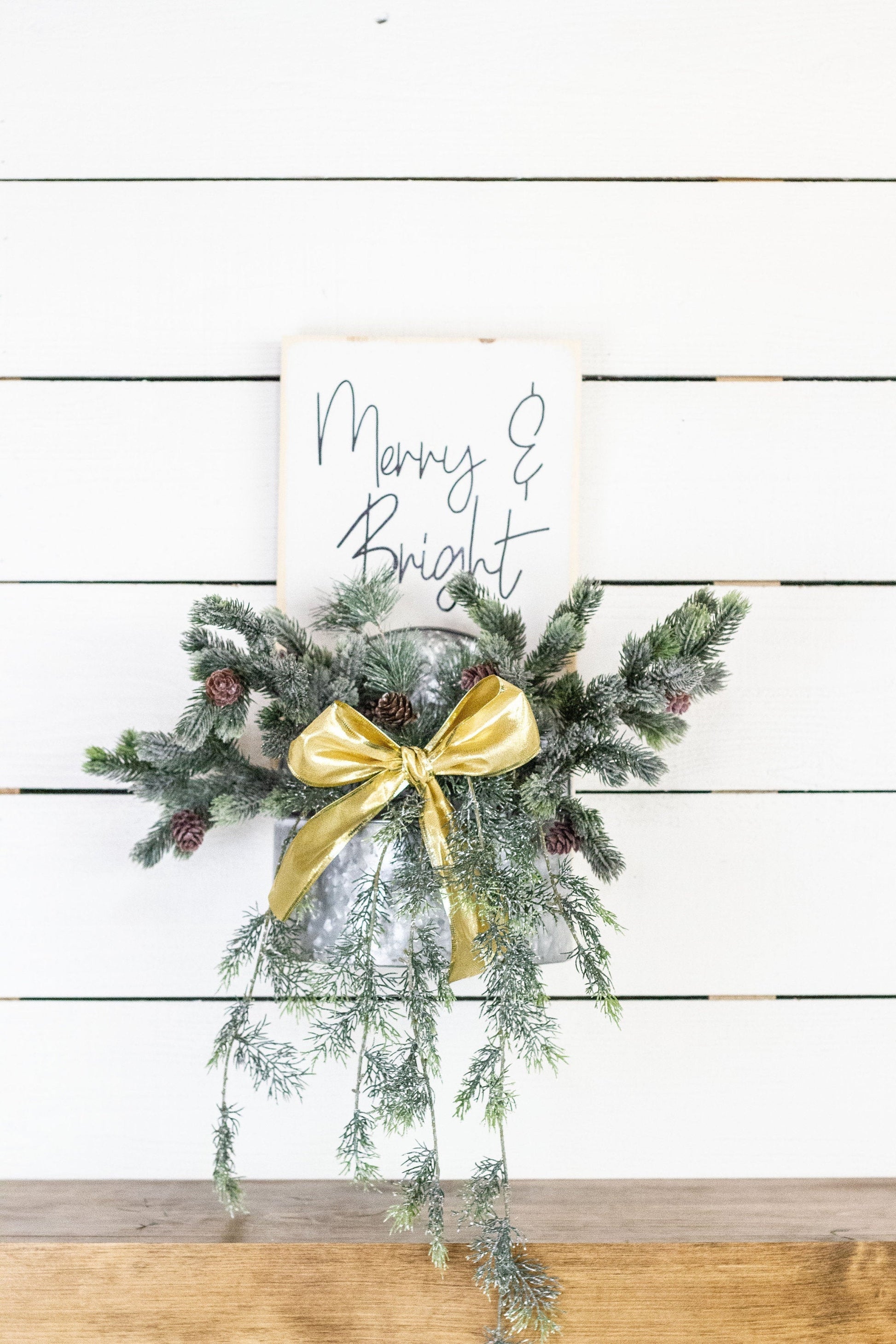 Rustic pine wood wall sign with festive greenery and metal planter